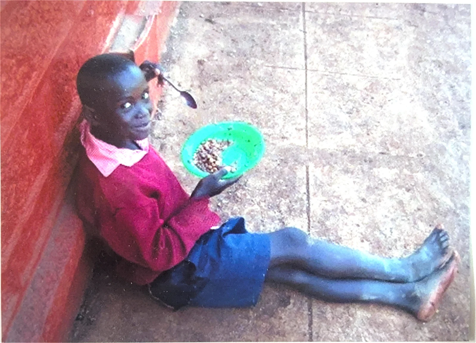 A Kenyan child receives a school meal during a Smiles Bring Hope community visit
