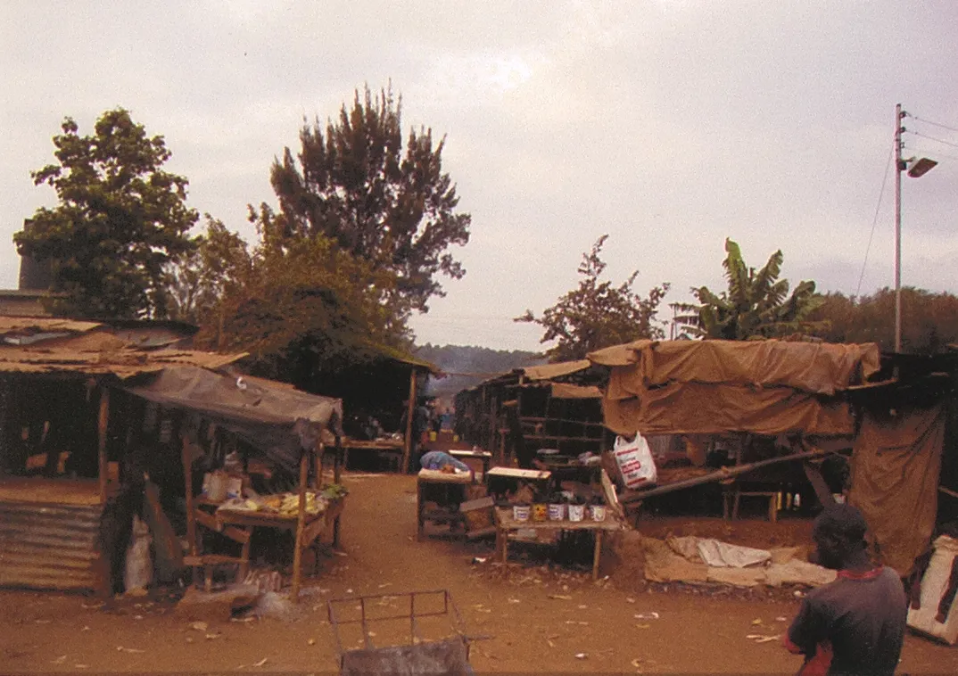 Market stalls and homes along a dirt road in the Kibera settlement, Nairobi, Kenya